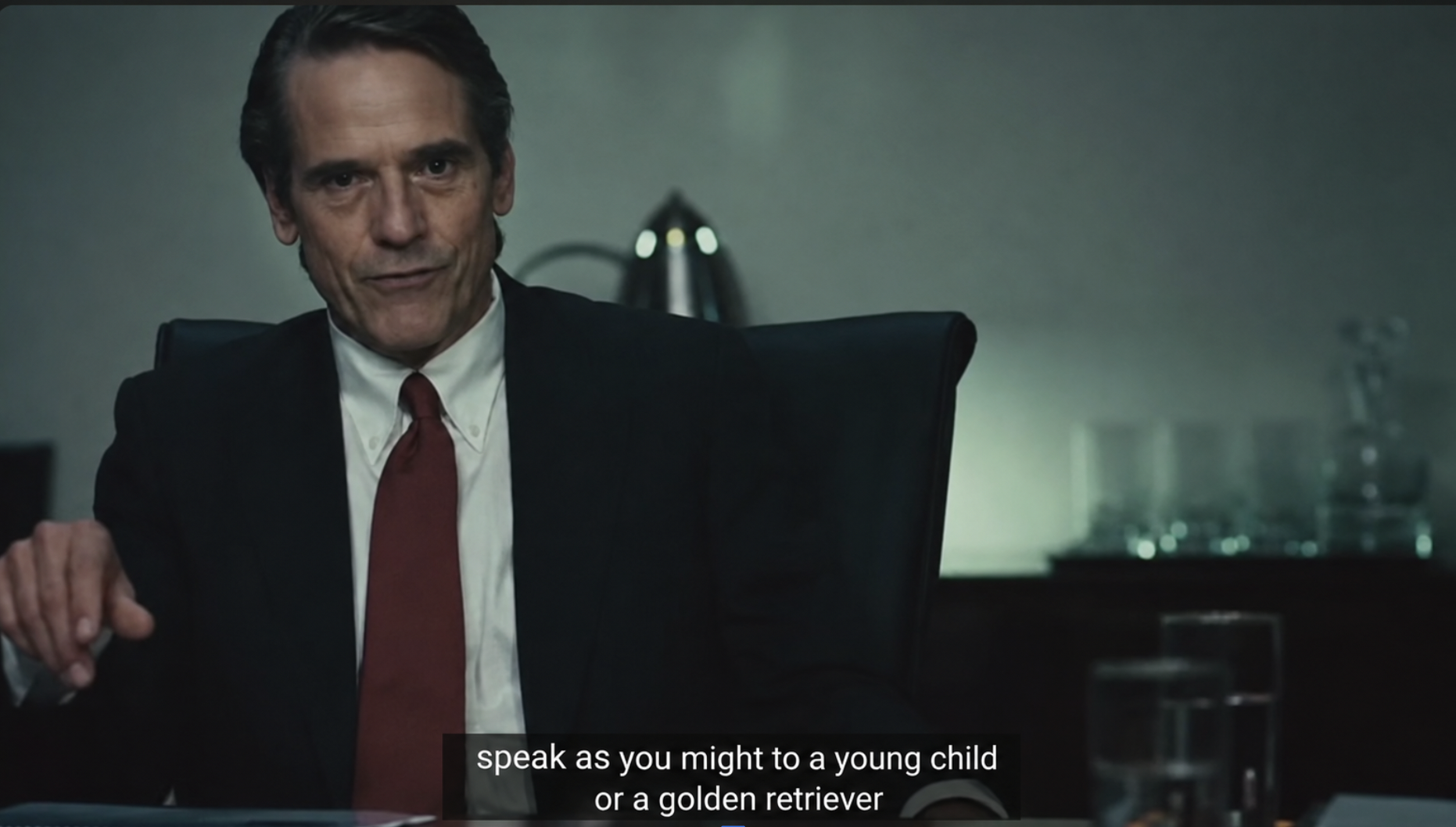 Jeremy Irons in Margin Call, seated beneath the subtitle speak as you might to a young child or a golden retriever